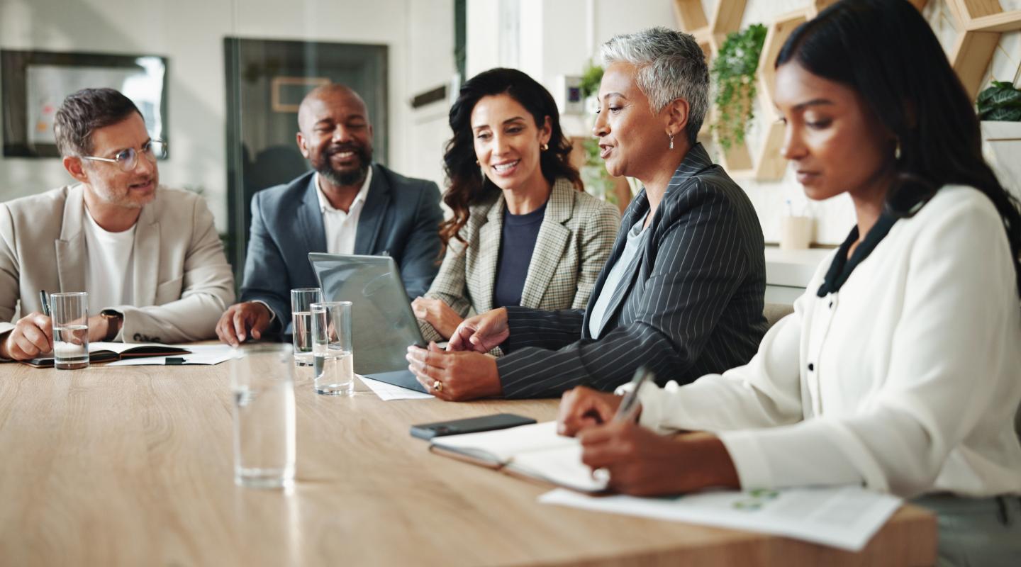 Group of professionals in a modern office meeting room, collaborating
