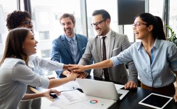 Business-and-professional-services.jpeg Happy professionals in an office with their hands together in a circle