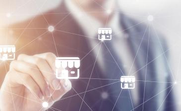 Man in business suit pointing to white business graphic