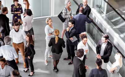 Aerial view of professionals networking in a bright room, at a conference