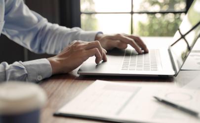 Male professional, hands working on a laptop