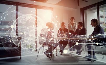 Group of professionals in a glass office in a meeting, with white graphics of a globe, lines and dots representing technology