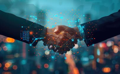 Two professionals shake hands amid digital graphs and colleagues' silhouettes, symbolizing teamwork