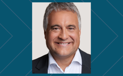 man with grey hair in a suit smiling