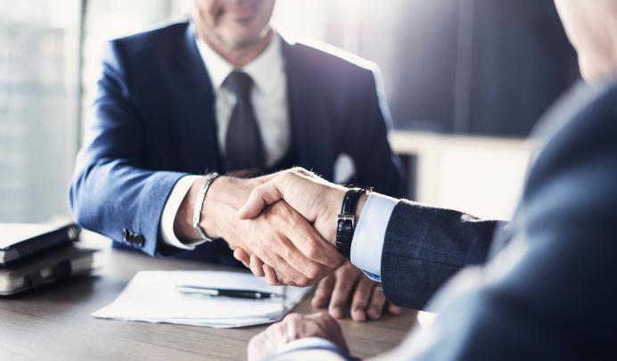 Two businessmen shaking hands at a meeting