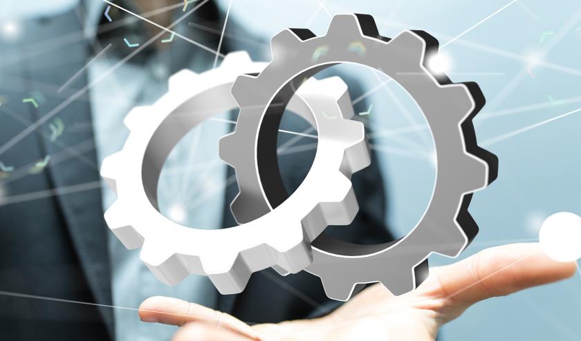 Businessperson holding two intertwined gears