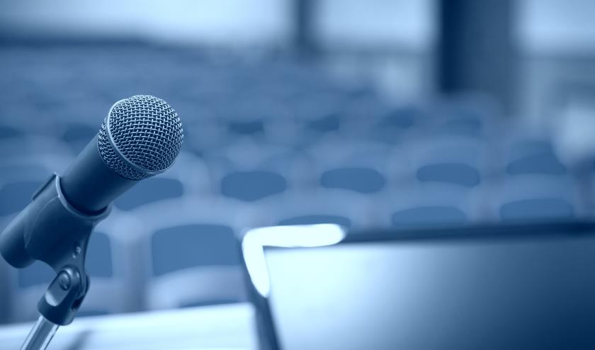 View from a stage, looking at a microphone and auditorium seating
