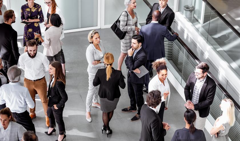 Aerial view of professionals networking in a bright room, at a conference