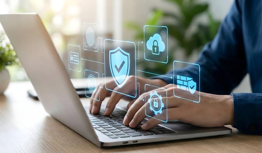 Male professional working on laptop, blue floating graphics of locks, security, cloud, technology above the laptop