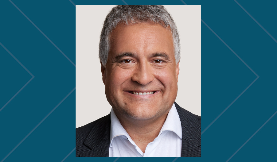 man with grey hair in a suit smiling
