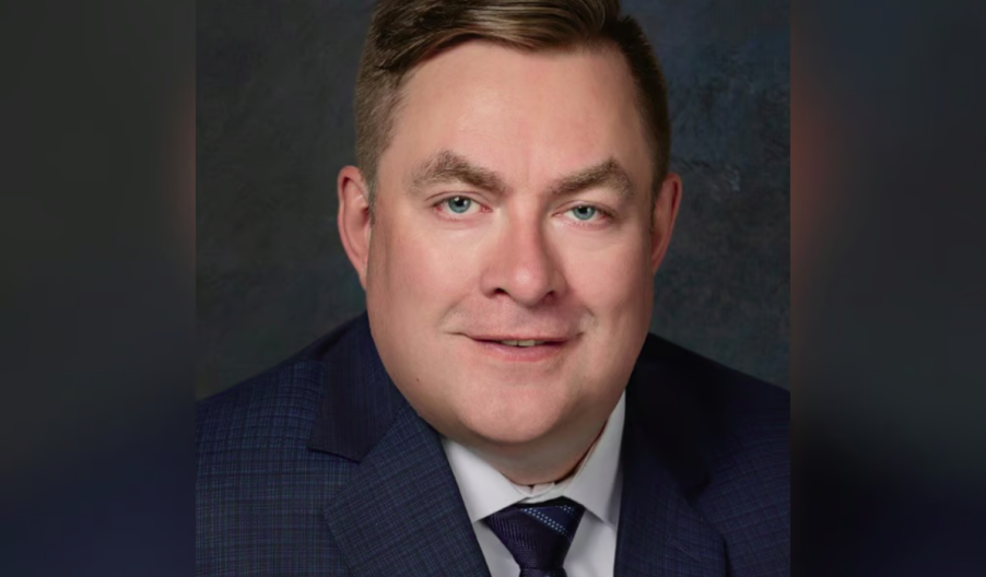 man with light hair and green eyes wearing a suit